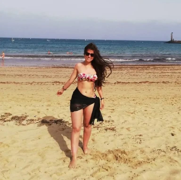 Portrait d'une femme aux hanches larges souriante vêtue avec élégance et style.