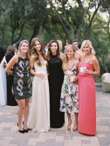 Image d'un groupe de femmes habillées de façon élégante pour assister à un mariage, posant pour une photo.
