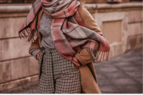 Relooking femme hiver : look chic avec manteau camel et écharpe à carreaux Relooking femme hiver élégant avec manteau camel, pantalon à carreaux, pull gris et écharpe chaude à motifs